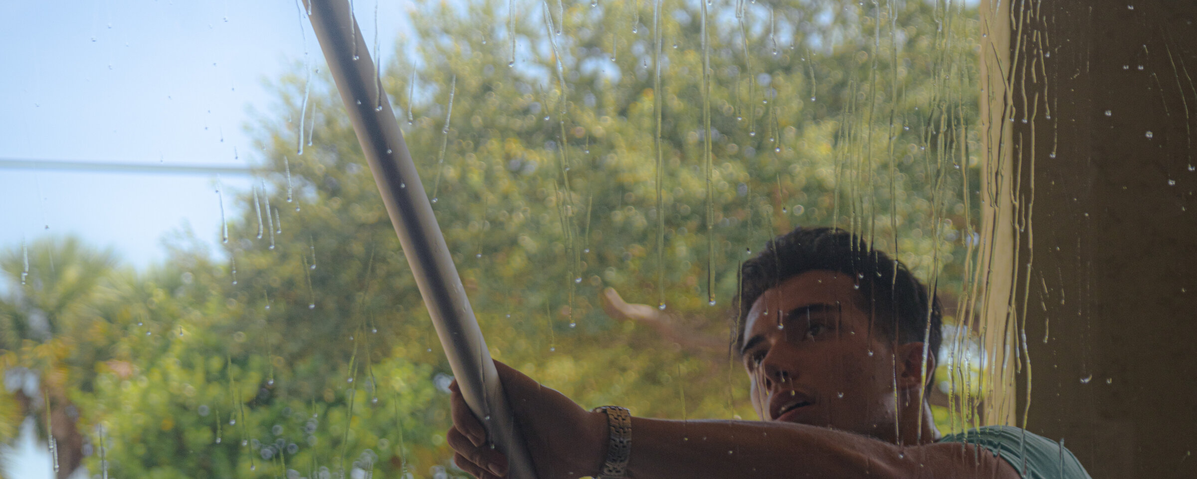 Coastal King technician cleaning windows at a luxury Palm Beach County home