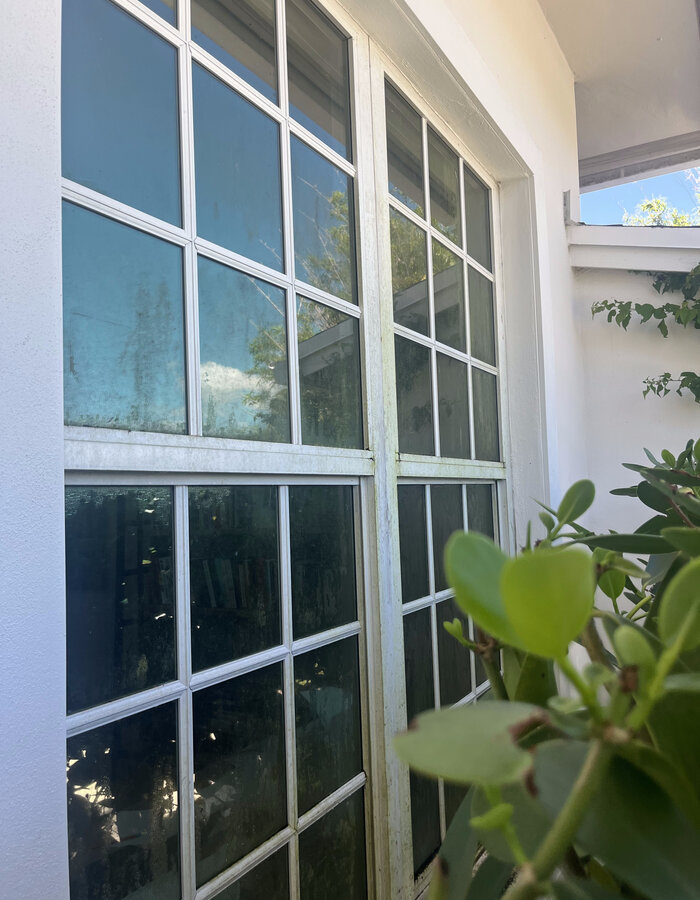 Window with streaks and residue before Coastal King cleaning